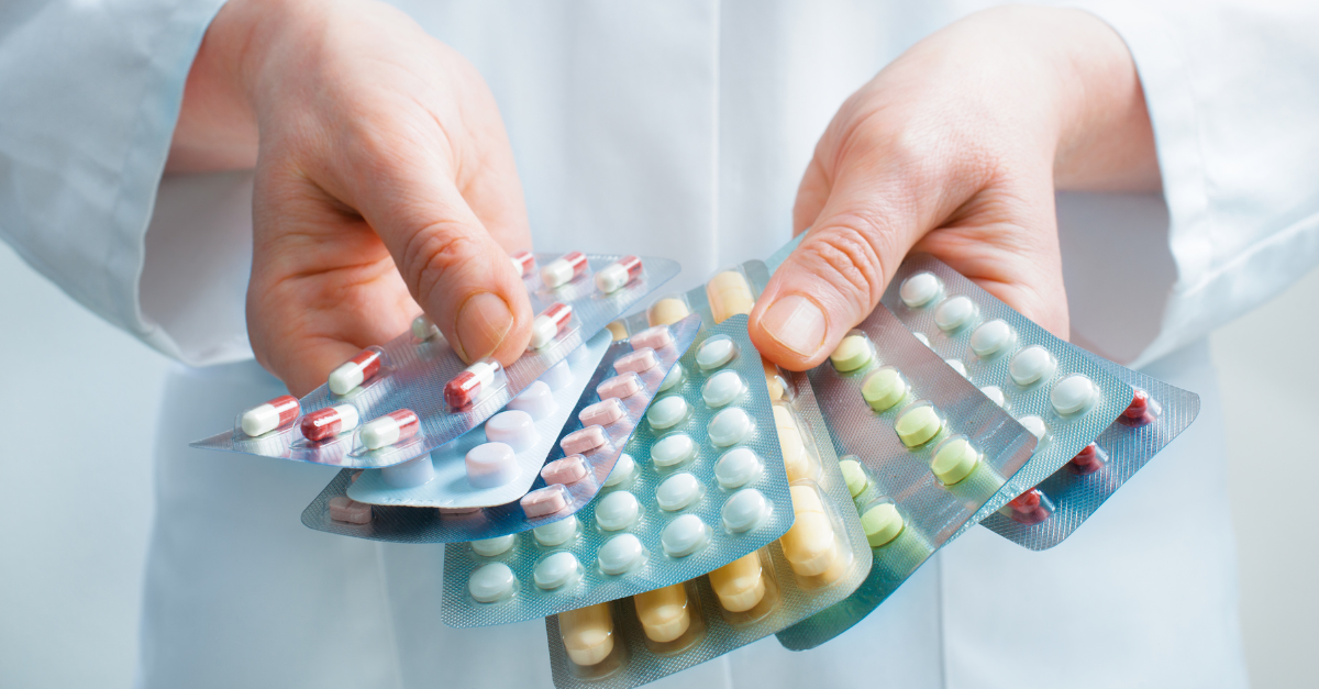 A person holding multiple opioid pills.